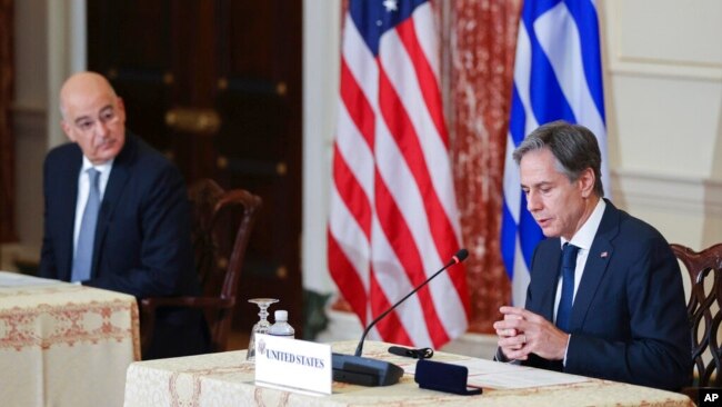 Secretary of State Antony Blinken speaks as Greece's Foreign Minister Nikos Dendias looks on during an event at the State Department in Washington, Oct. 14, 2021.