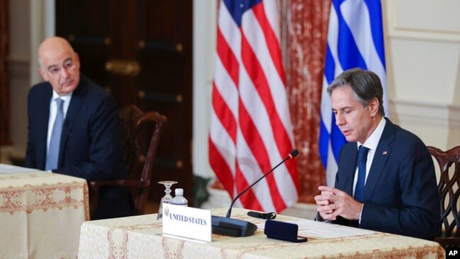 Secretary of State Antony Blinken speaks as Greece's Foreign Minister Nikos Dendias looks on during an event at the State Department in Washington, Oct. 14, 2021.