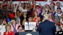 Supporters cheer for President Donald Trump, right, during a rally, Aug. 4, 2018, in Lewis Center, Ohio.