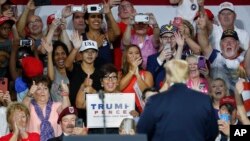 Supporters cheer for President Donald Trump, right, during a rally, Aug. 4, 2018, in Lewis Center, Ohio. 