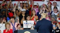 Supporters cheer for President Donald Trump, right, during a rally, Aug. 4, 2018, in Lewis Center, Ohio. 