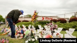 资料照片：美国纽约州布法罗发生种族主义枪击案的超市外摆满了鲜花。（2022年5月20日）