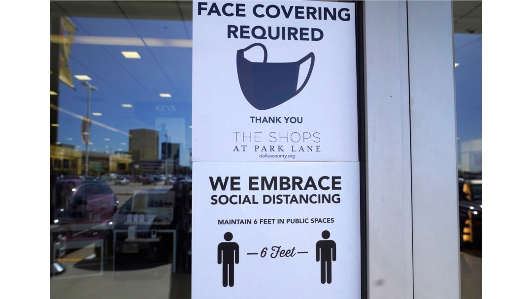 Signs tells customers about safety measures against COVID-19 that are required inside a retail store Tuesday, March 2, 2021, in Dallas.