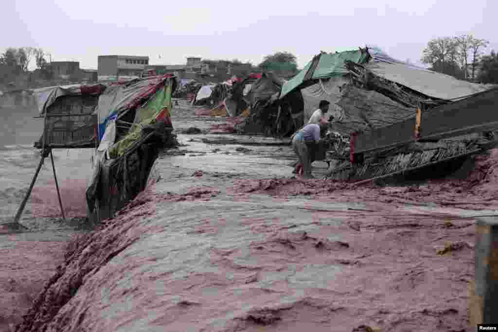 파키스탄 페샤와르 외곽에서 폭우로 홍수가 발생한 가운데, 노점상 상인들이 물건을 옮기고 있다.