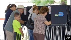 FILE - Florida voters fill out there ballots in the primary election, August 30, 2016, in Hialeah, Florida. A federal judge extended the deadline to register to vote in Florida in the wake of Hurricane Matthew.