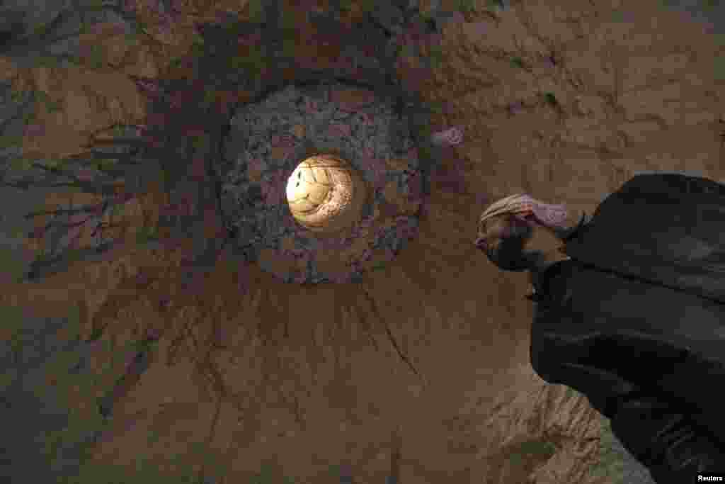 A man is seen in a cave that is used as a shelter, under his house, in Kafruma, an area in the Syrian province of Idlib October 26