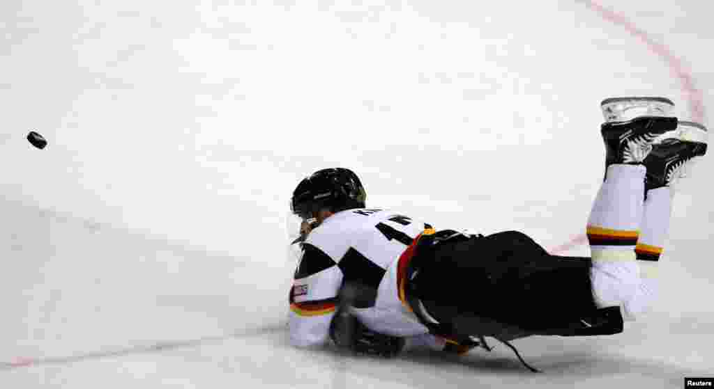Germany&#39;s Marcus Kink watches the puck as he falls during their 2013 IIHF Ice Hockey World Championship preliminary round match against Austria at the Hartwall Arena in Helsinki, Finland. 