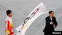 Nanjing Mayor Ji Jianye (R) waves the Olympic flag beside Chinese athlete Gao Tingjie during the closing ceremony of the Singapore 2010 Youth Olympic Games (YOG) at the Marina Bay Floating Platform in Singapore, Aug. 26, 2010. 