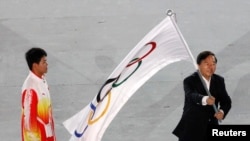 Thị trưởng Nam Kinh Quý Kiến Nghiệp phất cờ Olympic trong lễ bế mạc Đại hội thể thao Olympic trẻ tại Singapore năm 2010.