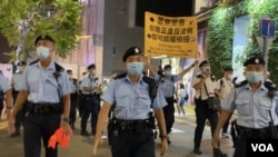 軍裝警員6月4日晚在銅鑼灣渣甸坊一帶舉牌警告，驅散聚集悼念六四的市民。(美國之音湯惠芸)