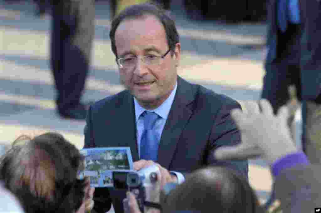 Francois Hollande, Socialist Party candidate for the 2012 French presidential election, shakes hands with people after his speech at a ceremony in Paris to mark the mass killing of Armenians by Ottoman Turks 97 years ago Tuesday, April 24, 2012. (AP Photo