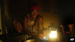 A displaced girl sits in a Monrovia hotel without electricity or water preparing lunch for her family on Tuesday, Sept 2, 2003.