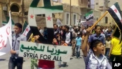 In this citizen journalism image, a protester holds up a Cross and Crescent painted with colors of the Syrian revolution flag during a demonstration against Syrian President Bashar Assad, May 18, 2012. 