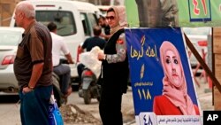 A poster of a woman candidate for parliamentary elections is seen at a bus stop in Baghdad, Iraq, April 22, 2018.