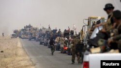Shi'ite paramilitaries riding military vehicles travel from Lake Tharthar toward Ramadi to fight against Islamic state militants, west of Samarra, Iraq, May 27, 2015.