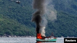 Kapal nelayan tak berawak dari Vietnam diledakkan dan ditenggelamkan oleh angkatan laut Indonesia di lepas pantai Anambas, Kepulauan Riau (5/12). 