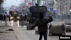 A protester throws a stone at police during clashes in Pristina, Kosovo, Jan. 9, 2016. Demonstrators in Kosovo fought running battles with police and briefly set fire to government headquarters on Saturday in the latest violence in the young Balkan country over an accord with its former ruler Serbia. 