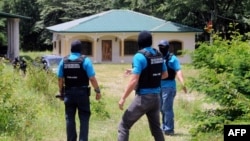 Image released by the Honduran government shows Honduran authorities at a seized property in Copan, which belongs to the family of Digna Azucena Valle, who is imprisoned in the US on drug charges, August 18, 2014. 