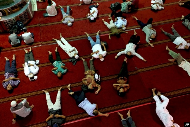 Muslim men nap as they wait for the time to break their fast after Friday prayer at the Istiqlal Mosque in Jakarta, Indonesia, Friday, June 9, 2017.