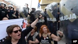 FILE - In this May 1, 2018, file photo, anti-fascists shout slogans against members of the far-right National-Radical Camp in Warsaw, Poland. 