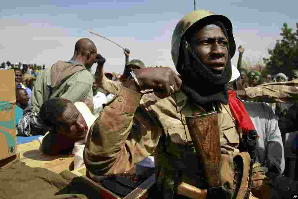 Malian soldiers guard suspected Islamist extremists after throwing them in the back of the army truck in Gao, Mali, January 29, 2013.