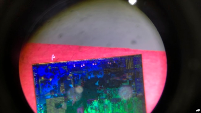 A Chinese microchip is seen through a microscope set up at the booth for the state-controlled Tsinghua Unigroup project which is driving China's semiconductor ambitions.