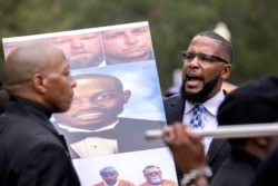 FILE - Dozens of Black Lives Matter and Black Panther protesters gather outside the Glynn County Courthouse where the trial of Travis McMichael, his father, Gregory McMichael, and William 'Roddie' Bryan is held, Nov. 22, 2021, in Brunswick, Ga.