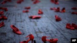 FILE: Red shoes are displayed as part of a protest highlighting violence against women at the Sant Jaume square in Barcelona, Spain, Nov. 21, 2016. The protest is a tribute to the victims of femicide, with each pair of shoes representing a victim of gender violence. 