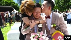 Shane Lin (tengah) dihibur oleh pasangannya Marc Yuan (kanan) dan seorang teman dalam upacara pernikahan di distrik Shinyi di Taipei, 24 Mei 2019. (Foto: Sam Yeh/AFP)
