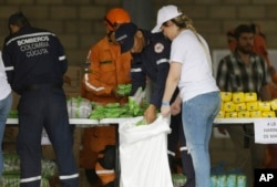 Venezuelan volunteers, Colombian firefighters and rescue workers prepare USAID humanitarian aid for storage at a warehouse next to the Tienditas International Bridge, near Cucuta, Colombia, on the border with Venezuela, Feb. 8, 2019.