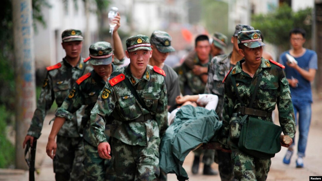 Polisi paramiliter China mengangkut korban tewas dan luka-luka di kota Ludian, provinsi Yunnan (3/8).