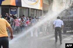 Police crack down with water cannons on a protest against the approval of a constitutional amendment for presidential reelection, outside Congress in Asuncion, March 31, 2017.
