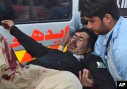 Pakistani staff help an injured police officer shifting to a hospital in Quetta, Pakistan, April 24, 2018.