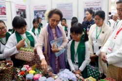 Pemimpin Myanmar Aung San Suu Kyi, tengah, melihat keranjang buatan sendiri yang dipajang saat pertemuan implementasi Myanmar Education Development di Myanmar International Convention Center di Naypyidaw, Myanmar, Selasa, 28 Januari 2020. (Foto: AP)