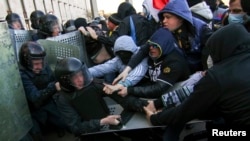 Pro-Russia protesters (R) scuffle with the police near the regional government building in Donetsk, April 6, 2014.
