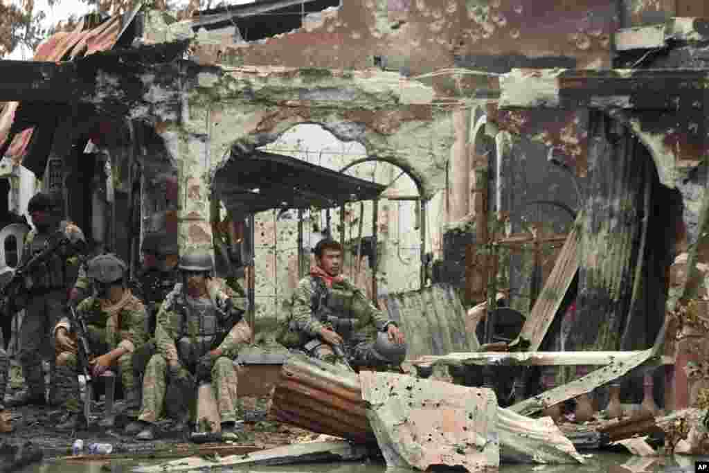 Government troops rest amidst the ruins at the site of a three-week standoff with Muslim rebels in Zamboanga City, southern Philippines.