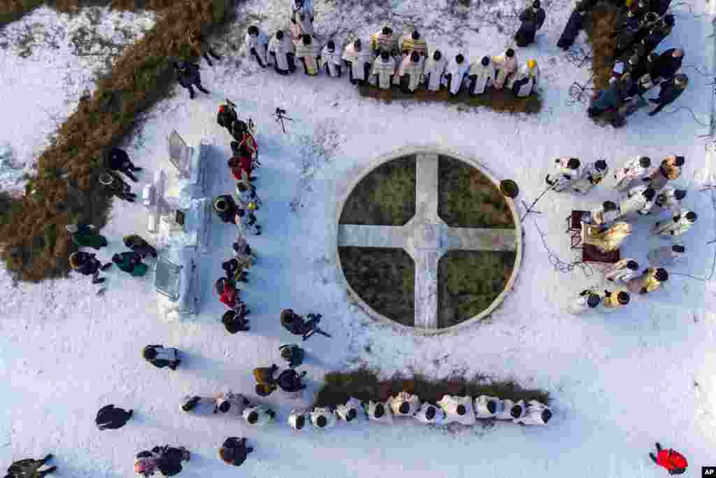 Orthodox priests conduct a religion service blessing the ice water of the Tura river during a traditional Epiphany celebration as the temperature is about -5&deg; C (23&deg; F) at the Holy Trinity Monastery in Tyumen, Russia.