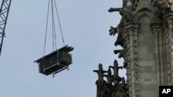 Una grúa levanta andamios junto a las gárgolas frente a la catedral de Notre Dame en París. Ya casi mil millones de dólares han provenido de fieles comunes y magnates de gran potencia de todo el mundo para restaurar la catedral.