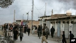 Localni stanovnici okupljaju se na ulici dok se dim diže iznad mesta eksplozije u Kveti