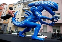 FILE - A figure representing hate speech on Facebook is seen featured during a carnival parade in Duesseldorf, Germany, Feb. 24, 2020.