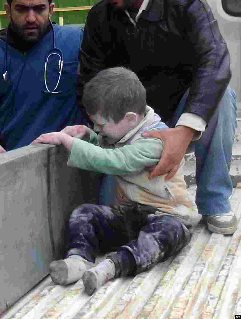 Syrians help an injured child following an alleged airstrike by government forces near a school in the northern city of Aleppo.