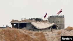 Russian and Syrian national flags are pictured near the northern Syrian village of Zor Magar, as seen from the Turkish border town of Karkamis in Gaziantep province, Turkey, Oct. 23, 2019.