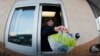 FILE – A fast food restaurant worker hands a patron a salad at a drive up window in Williamsville, New York. 