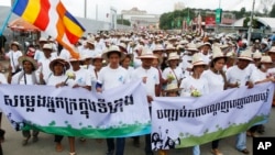 Cambodians hold banners reading "Voice of the poor in the city" left, and "Stop Forced Evictions" right, as they march to the National Assembly during a rally to mark World Habitat Day, in Phnom Penh, Cambodia, file photo.