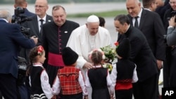 Pope Francis is welcomed by children wearing traditional dresses upon his arrival in Sofia, Bulgaria, May 5, 2019. Pope Francis is visiting Bulgaria, the European Union's poorest country and one that taken a hard line against migrants, a stance that confl