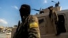 FILE - U.S.-backed Syrian Democratic Forces fighters stand guard at Al Naeem Square, in Raqqa, Syria, Feb. 7, 2022. 