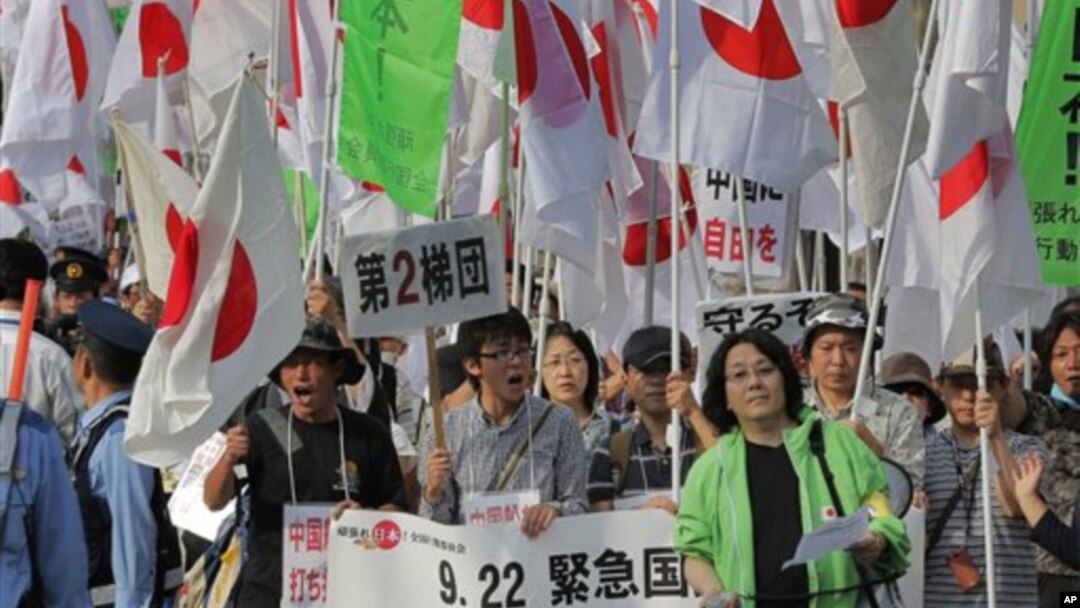 Ratusan pengunjuk rasa di Tokyo (22/9) menggusung bendera Jepang dalam aksi protes menentang klaim Tiongkok atas pulau sengketa Sengkaku (dalam bahasa Jepang). Pulau ini disebut Diayou dalam bahasa Tiongkok.