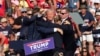 FILE - U.S. Secret Service agents surround Republican candidate Donald Trump as he is taken off the stage after an assassination attempt at a campaign event in Butler, Pennsylvania, July 13, 2024. Conspiracy theories have thrived since the event, even halfway across the world.