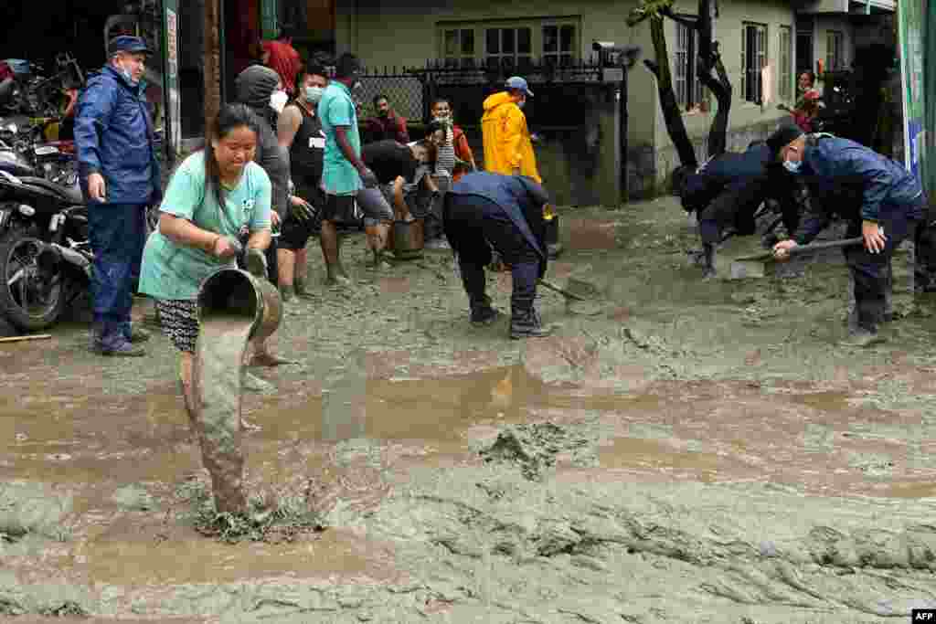 Residents and rescue workers clean an area which was flooded after Bishnumati river overflowed following heavy monsoon rains in Kathmandu, Nepal.