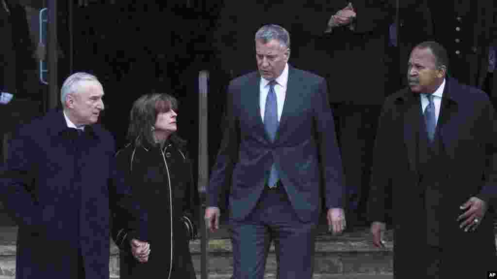 From left, New York Police Department Commissioner Bill Bratton, Rikki Klieman, Bratton's wife, New York City Mayor Bill de Blasio, and 1st Deputy Commissioner Benjamin Tucker exit the wake for New York Police Department Officer Wenjian Liu at a funeral h